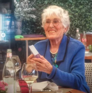 une personne de 84 ans sourit a sa famille lors de son anniversaire dans un joli restaurant 